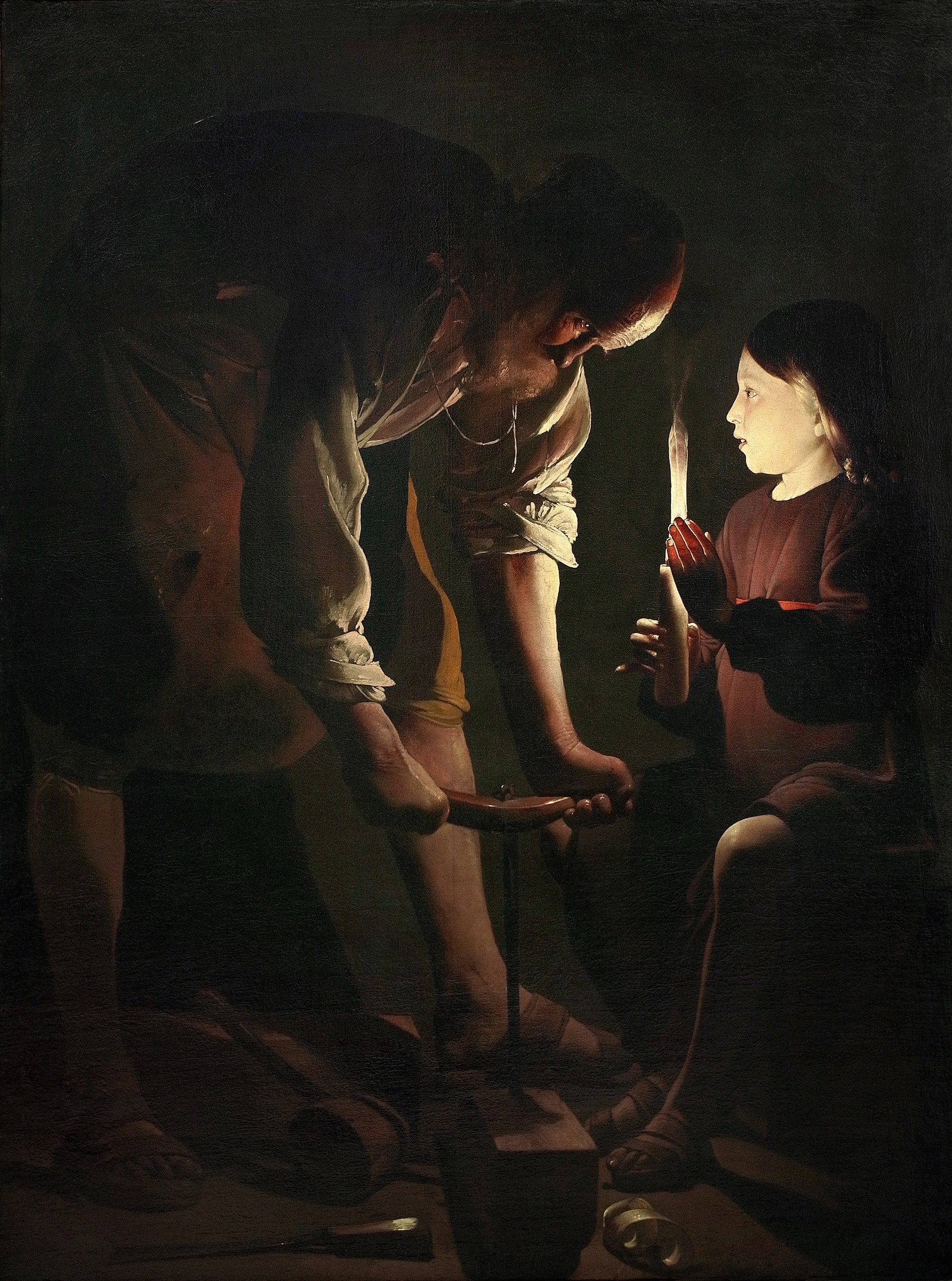 San José taladra un madero de noche mientras el Niño Jesús sostiene una vela que ilumina la escena, en la obra de Georges de La Tour.